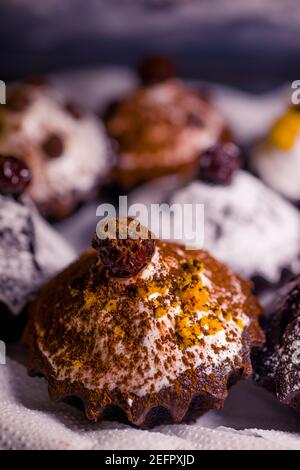 chocolate muffins sprinkled with goodies with cherries and chocolate and cocoa Stock Photo