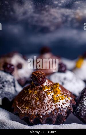 chocolate muffins sprinkled with goodies with cherries and chocolate and cocoa Stock Photo