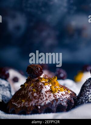 chocolate muffins sprinkled with goodies with cherries and chocolate and cocoa Stock Photo