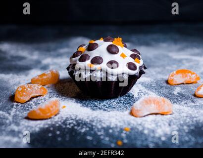 chocolate muffins sprinkled with goodies with cherries and chocolate and cocoa Stock Photo