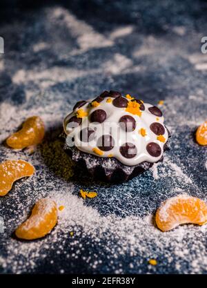 chocolate muffins sprinkled with goodies with cherries and chocolate and cocoa Stock Photo