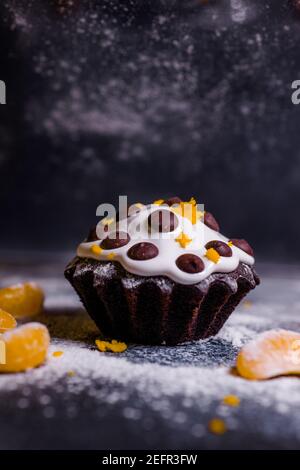 chocolate muffins sprinkled with goodies with cherries and chocolate and cocoa Stock Photo