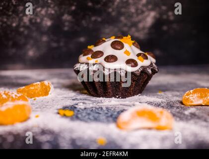 chocolate muffins sprinkled with goodies with cherries and chocolate and cocoa Stock Photo
