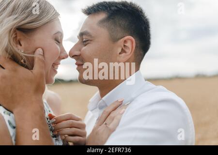 Man and woman kissing in the background of a field. Happy couple in a wheat field Stock Photo