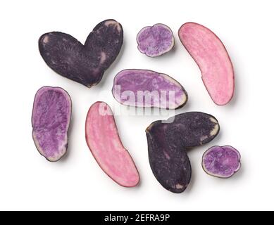 Blue, purple and red potatoes of various shapes and colors, sliced in halves isolated on white background. Stock Photo