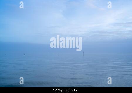 Cloudy blue minimalist seascape. Deserted space with horizon line.
