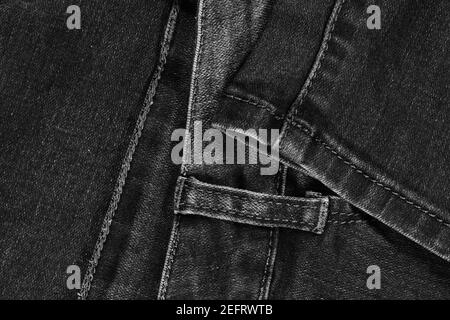 Black jeans fabric (denim). View of the waistband and leg stitches. Stock Photo