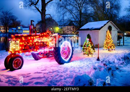 Ornamented and Lit Tractor and Christmas Trees in the Yard, Red Mill Museum Village, Clinton, Hunterdon County, New Jersey Stock Photo