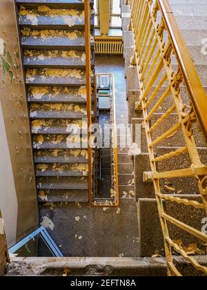 Dirty concrete staircase with metal railings in old abandoned hospital Stock Photo