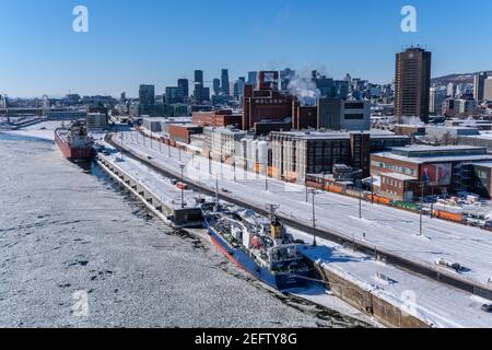 MONTREAL, CA - 17 February 2021: View of Montreal Skyline and frozen Saint-Lawrence River from Jacques Cartier Bridge Stock Photo