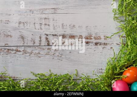 Three colored easter eggs in the lower right-hand corner with green easter grass along border, with copy space Stock Photo