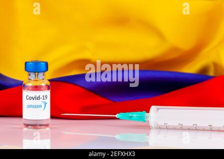 BOGOTA, COLOMBIA - FEBRUARY 2021. Janssen covid vaccine vial and Colombian flag. Vaccination concept. Stock Photo