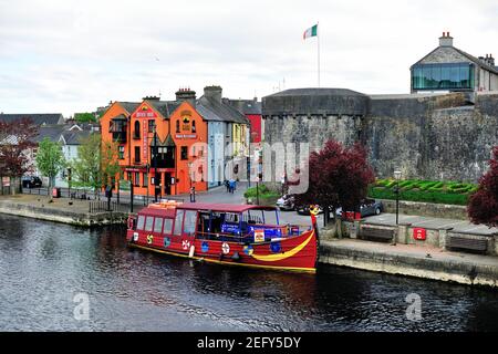 Athlone, County Westmeath, Ireland. Colorful boats tied up in the River Shannon along tidy homes and buildings. Stock Photo