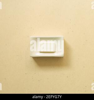 Soap bar in ceramic bowl on beige background. Bathroom. top view Stock Photo