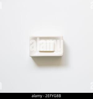 Soap bar in ceramic bowl on white background. top view Stock Photo