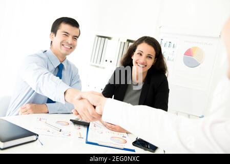 Businessmen making handshake in meeting room Stock Photo