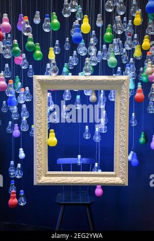 Multi-colored bulbs and a white frame hanging from the ceiling. Stock Photo