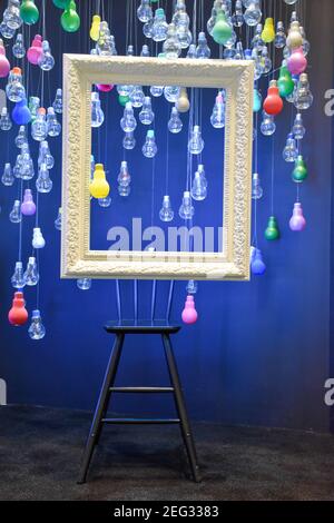 Multi-colored bulbs and a white frame hanging from the ceiling. Stock Photo