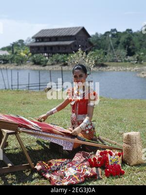 Asia,Malaysia, Sarawak, Sarawak Cultural Village pretty Iban girls wearing  Traditional Costume doing Traditional Weaving Stock Photo