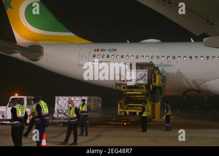 Dakar, Senegal. 17th Feb, 2021. Workers unload the first batch of China's Sinopharm COVID-19 vaccine at Blaise Diagne International Airport in Dakar, Senegal, Feb. 17, 2021. Senegal on Wednesday night received the first batch of China's Sinopharm COVID-19 vaccine. Credit: Xing Jianqiao/Xinhua/Alamy Live News Stock Photo