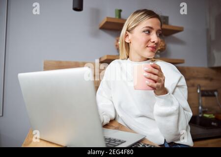 Woman getting distracted from job while drinking tea Stock Photo