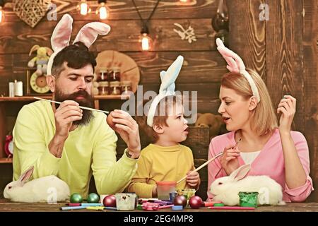 Happy family preparing for Easter. Father mother and son painting easter eggs. Stock Photo