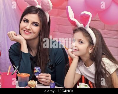 Happy Easter. Mother and child daughter with bunny ears hare getting ready for holiday. Stock Photo