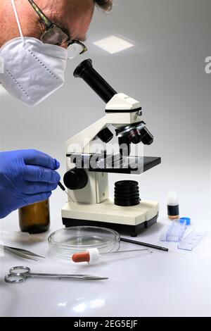 scientist looking through microscope Stock Photo