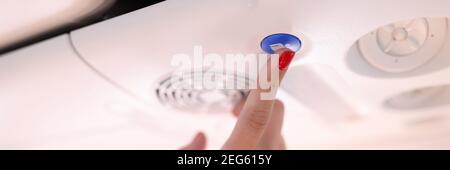Female hand press blue button on plane. Stock Photo
