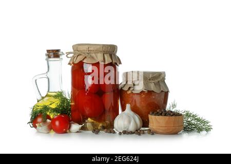 Jars with pickled tomatoes and adjika, and ingredients isolated on white background Stock Photo