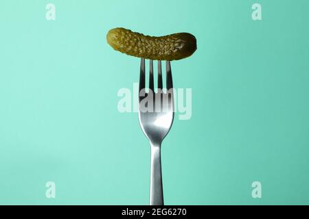 Fork with pickled cucumber on mint background Stock Photo