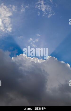 Rays of sunlight breaking above clouds Stock Photo