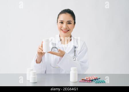 asian doctor looking capsule of vitamin or medicine in small glass bottle, for showing patient and prescription medicine before explain how to eat Stock Photo