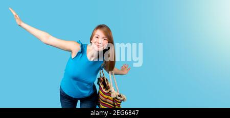 Banner,long format. A satisfied blonde on her shoulder with a beach bag, arms outstretched to the sides, looks at the camera and smiles on a studio