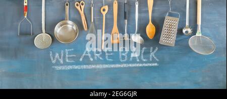 reopen sign, restaurant or cafe ready to service after corona lockdown, kitchen utensils and message we are back,concept, panoramic Stock Photo