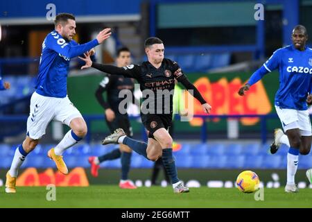 Liverpool, United Kingdom, 17th February 2021. Pictured left to right, Everton’s Gylfi Sigurdsson and Manchester City's Phil Foden in action. Credit: Anthony Devlin/Alamy Live News