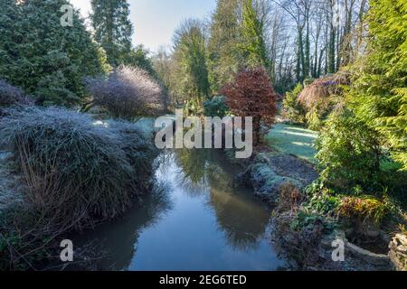 A small stream flowing though gardens at Cove in the Exe Valley in Winter, Devon, England. Stock Photo