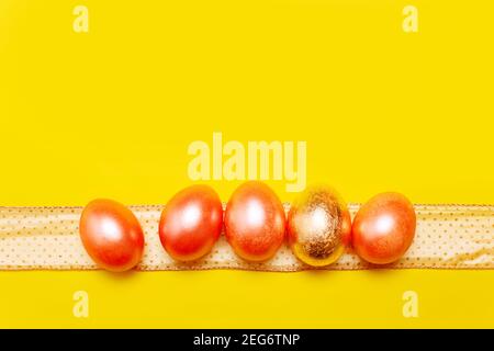 Modern trendy easter concept with five colored pink and golden eggs over bright yellow background Stock Photo
