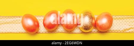 Modern trendy easter concept with five colored pink and golden eggs over bright yellow background, banner Stock Photo