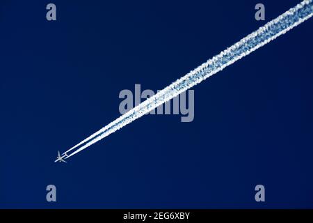 Low angle shot of a plane flying high up in the sky Stock Photo