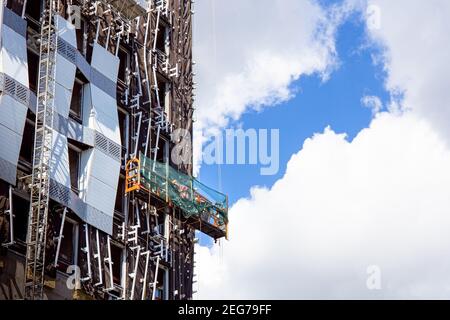 Builders worker installing glass windows on facade of business building Stock Photo