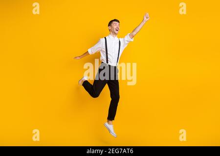 Full length body size photo jumping dreamy man keeping hand up imagine keeping umbrella isolated on vivid yellow color background Stock Photo