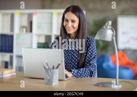 Photo of young attractive charming happy cheerful smiling positive businesswoman working in computer at office workshop Stock Photo