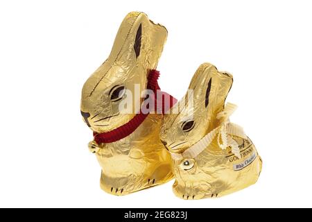 London, UK - February 15, 2021: Two Lindt Gold Easter Bunnies with their golden bells on a white background.  One is milk chocolate and the other is w Stock Photo