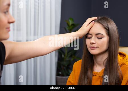 Psychotherapist supporting her depressed female patient. Close up photo, indoor office Stock Photo