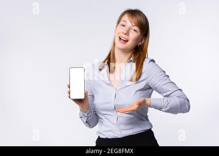 Portrait of happy blonde woman showing white screen of her smartphone Stock Photo