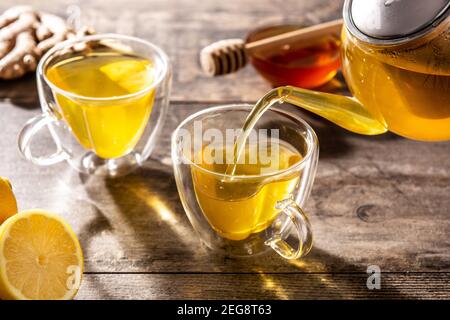 Pouring ginger tea with lemon and honey in a cup Stock Photo