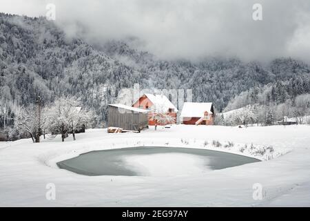 Fantastic landscape with snowy mountains, trees and houses. Carpathian mountains, Ukraine, Europe Stock Photo
