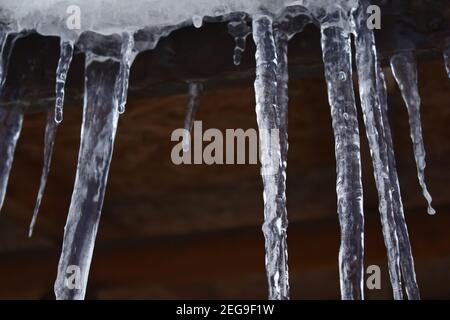 Sharp and dangerous icicles hanging. Cold weather. Winter concept. Stock Photo