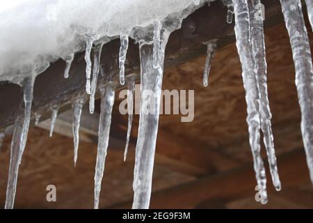 Sharp and dangerous icicles hanging. Cold weather. Winter concept. Stock Photo